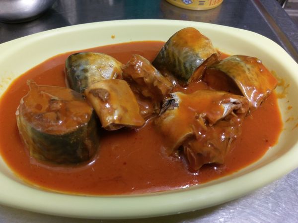 將魚肉和湯汁從罐頭中倒出來