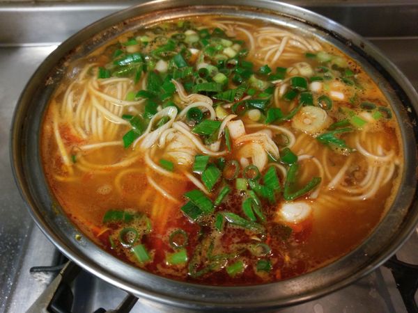 用少許白胡椒粉提味，將2/3的蔥花蒜苗加入過中