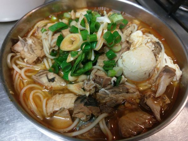 把麵及湯汁盛放進碗中，再灑上剩下的蔥花及蒜苗就完成了