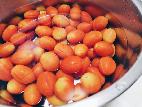 煮一鍋沸水、備一鍋冷的過濾水跟準備一支漏勺；
水大滾的時候，將一些蕃茄放到漏勺上再放入沸水煮1分鐘後，撈起蕃茄放入冷過濾水中。
(分次煮蕃茄，避免一次下，水溫變太低，會泡很久）
＊不能煮太久不然蕃茄會過熟不Q