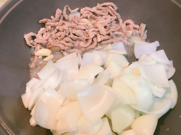 肉絲全熟後，加入洋蔥翻炒。
