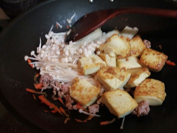 用半米杯水調開素蠔油，加入鍋中，連金針菇及雞蛋豆腐一起燒到水乾，下味素調味即可