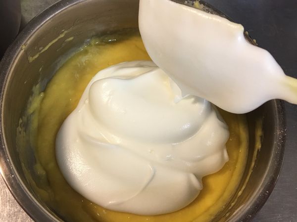 打好的蛋白先拿1/3到剛才拌好的麵糊攪拌均勻，切記要同個方向攪拌，攪拌動作不要過於用力，以免消泡