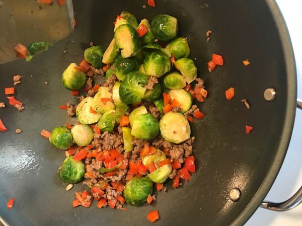 牛肉8分熟左右下孢子甘藍，撒鹽巴及彩色胡椒粉調味（黑胡椒也可以），炒至甘藍邊緣微焦可關火盛盤。