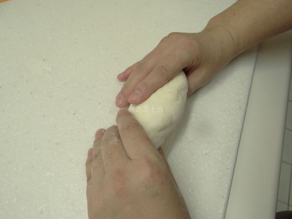 兩手抓麵團兩邊，往內折進來，黏合處向下