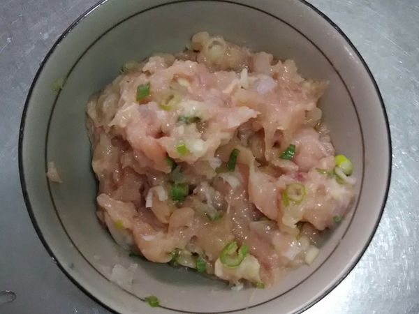 再來，將雞胸肉攪碎成雞胸肉絞肉，或是直接請肉攤幫您，接著就是切一些洋蔥及青蔥，以及雞蛋加進去雞胸絞肉裡，拌一點鹽巴，增加黏性稠度，然後挖取一點絞肉，兩隻手掌再互相交換這樣甩肉