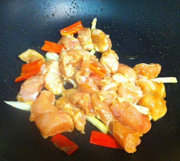 適量油熱鍋，先將蒜末、蔥白段、辣椒依序爆香後將雞丁倒入一起拌炒到表面金黃微焦盛起。