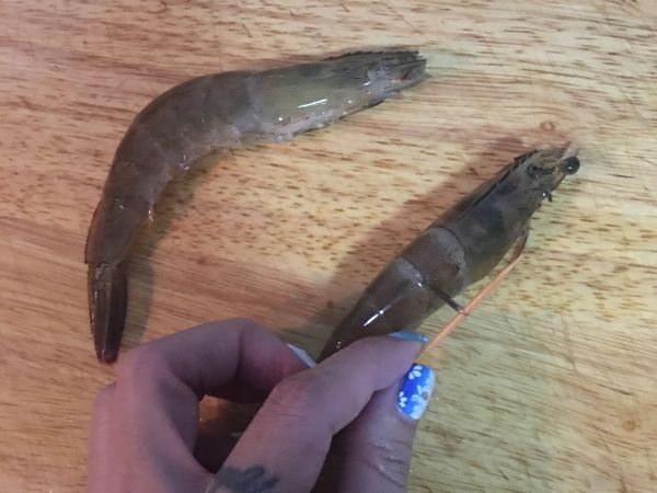 用剪刀剪去眼睛前的部份及鬚、腳等部位；並用牙籤從背部第二節部份挑除泥腸；