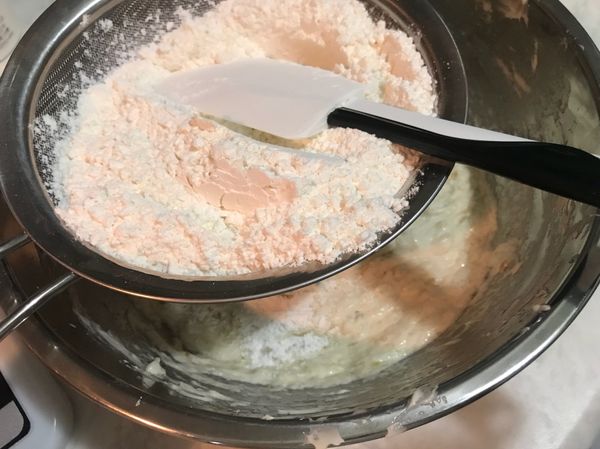 低筋麵粉及泡打粉過篩加入，使用刮刀由外而內拌勻。