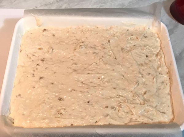 烤盤鋪上烤紙後，將香蕉蛋糕糊倒入，最後要輕震一下烤盤，讓麵糊能均勻分布在烤盤中，表面再用刮刀刮平整。