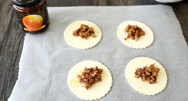 將冷凍酥皮放在室溫中回軟，印出圓形或正方形，將餡料放在酥皮中間，在四周塗上蛋液