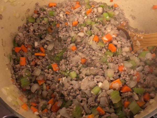 起鍋加入橄欖油或奶油，下蒜末炒出香氣後，開始下剛剛切好的洋蔥、芹菜、紅蘿蔔丁全部一起拌炒，炒到蔬菜微軟了再下碎肉拌炒。