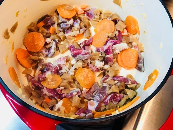 放入梅花肉、菜圃炒出香味，再加入紅蘿蔔薄片炒勻