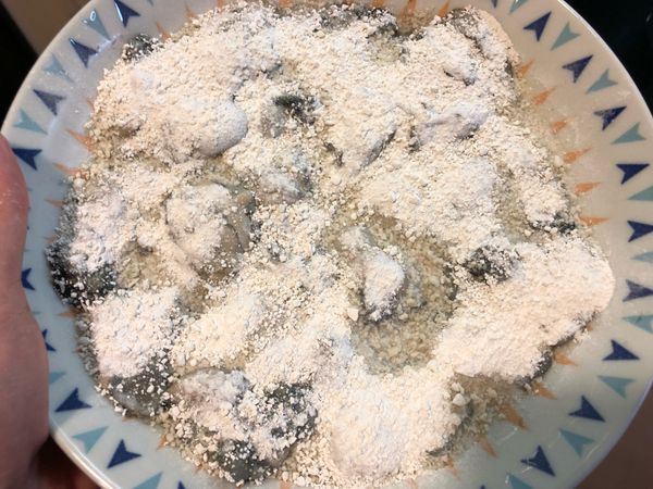 將鮮蚵洗淨瀝乾，ㄧ顆顆在盤內鋪平，均勻撒上地瓜粉（木薯粉）。