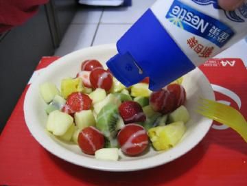 將水果倒入盤中妝盤並淋上鷹牌煉奶