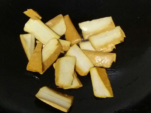 起鍋油熱，下豆干煎至稍微變金黃色後取出備用。