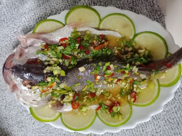 檸檬片先擺在盤子周邊，在把魚放在盤子中間，淋上醬汁，然後放進電鍋或(用瓦斯都可以)外鍋加半杯水蒸15分種就取出上桌完成