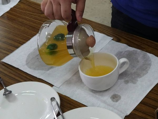 將紅茶杯內溫杯用的熱水倒掉→倒入調製好的熱柳橙金桔汁至8分滿。