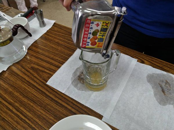 以榨汁器榨取金桔汁，倒入公杯。