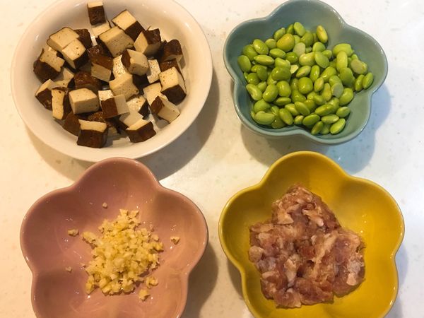 毛豆買回先用滾水川燙一下(約3～4分鐘)
豆干川燙後放涼，切小丁備用
蒜頭切末備用