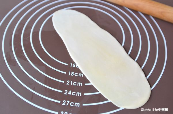 將剛才捏成球、鬆弛好的圓球，底部朝上用擀麵棍捍成長橢圓形