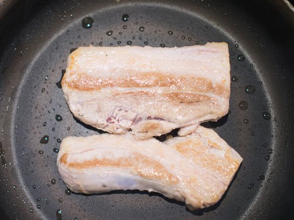 取一平底鍋，將豬五花兩面煎出顏色。
＊表面呈現金黃色即可，即使裡面沒熟也沒關係。