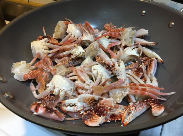 起油鍋，倒入螃蟹和蒜、薑末煎炒出香氣