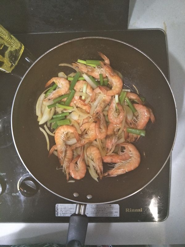 蝦子8分熟時，加一杯水，並加入咖哩粉及鹽。此時轉中小火燜煮，確認鍋內醬汁快收乾時，打開鍋蓋放蔥段稍微翻炒，即可起鍋囉~