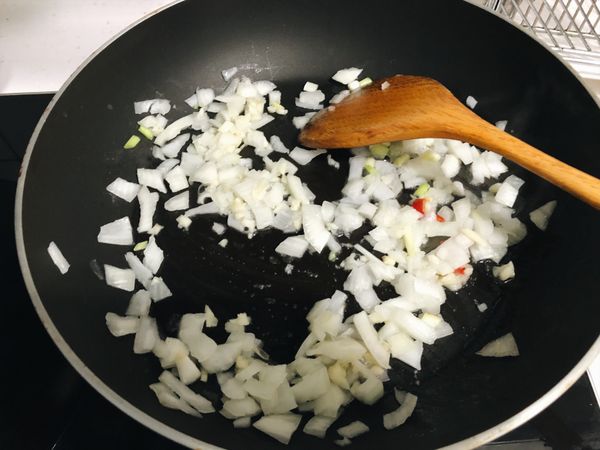 加入豬油（兩匙），先炒香蒜末一分鐘，再放入洋蔥、蔥白、辣椒拌炒數分鐘。