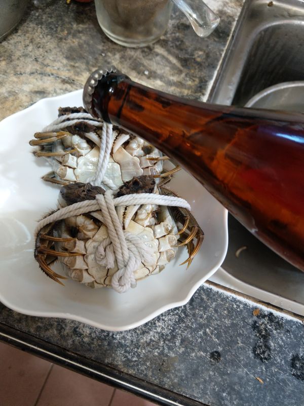 這邊要把螃蟹倒著放，不然蟹膏都流光光，吃不到蟹膏，加點米酒