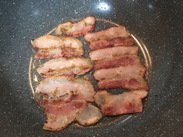 不沾鍋不用放油，排入培根將兩面煎上色，且逼出油脂；