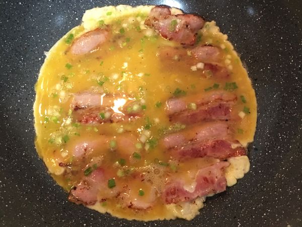 轉小火，倒入蔥花蛋液；