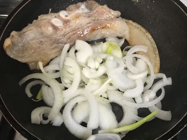 五花肉乾煸出油後，移至鍋邊繼續煸較肥的部分；並加入洋蔥拌炒