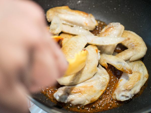 轉強火放入雞翅，攪拌使雞翅均勻包裹醬汁。