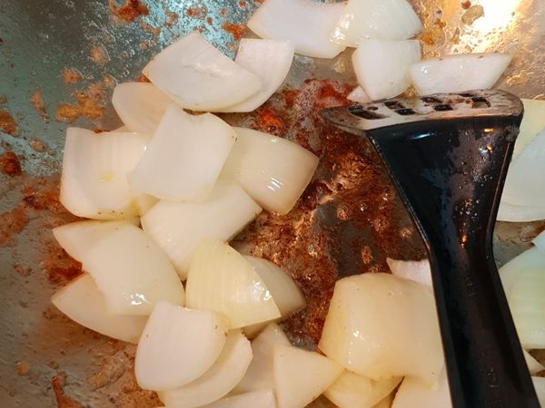 原鍋下洋蔥炒香，依序放入蔥段及牛肉，炒香至牛肉7分熟