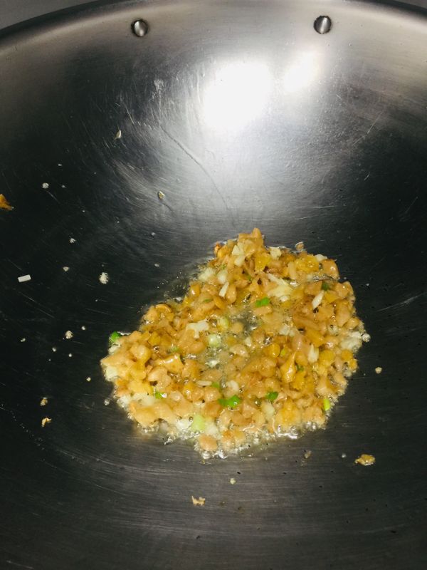 接著倒入橄欖油先炒香蒜末、蔥白和菜脯，炒出香味後倒入蛋液