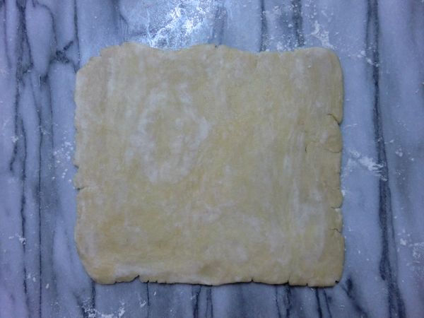 把冷藏的麵糰取出置於室溫中片刻，待麵糰至適合擀開的軟度時，在板上撒些手粉將麵糰擀至1/8吋的厚度。擀開麵檲時盡量要保持低溫，快速將麵檲從中心向四個方向擀開，不要來回擀動。擀開的途中需將派皮提起轉個方向，檢查派皮是否已黏在板上，派皮有沾黏時可再撒些手粉防沾。