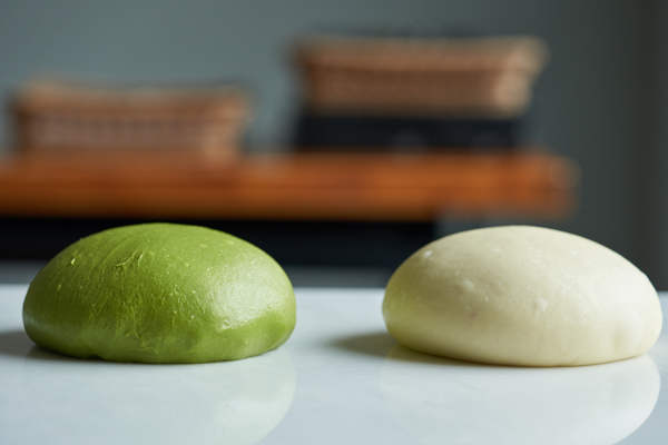 將發酵好的麵糰進行分割，白麵糰分割成255g,綠麵糰260g，在將麵糰進行滾圓。