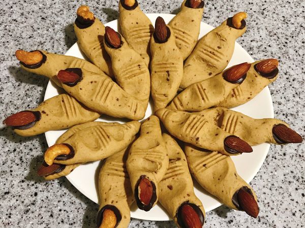 烤完出爐後略放涼，黑巧克力微波或隔水加熱融化，塗在手指的指甲凹槽然後放上杏仁果或腰果裝飾成指甲即完成！