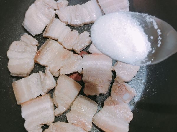待五花肉兩面皆變色略熟後，加入2大匙白糖