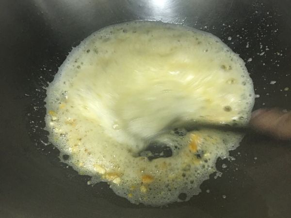 接著用鍋鏟快速繞圈，邊繞邊壓蛋黃；
