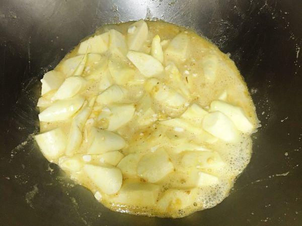 加入半杯的水和少許香菇精拌勻，蓋鍋蓋悶煮3～4分鐘；