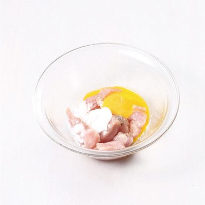 在太白粉沉澱物中加入1大匙的食用油，再放入醃過的肋脊肉拌勻。