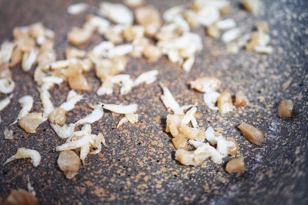 炒香配料：起油鍋，加一小匙的白芝麻油，其它油品也可以，加入蝦皮、蘿蔔乾，炒至聞到香味，不加油乾炒也是OK的。