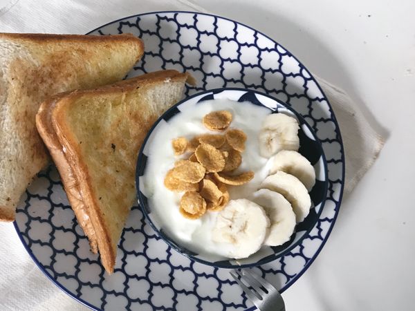 小碟子裡裝上優格，優格我吃低糖的，配上甜甜的香蕉片跟蜂蜜麥片剛好！