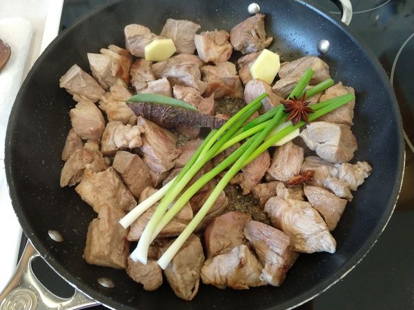 把另外半塊薑去皮切片, 連同3根青蔥, 八角, 桂皮和月桂葉一起放入鍋中, 炒至香味飄出