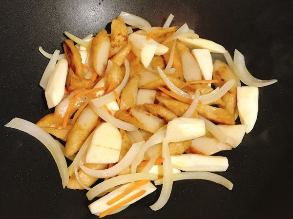 接著放入洋蔥絲爆香（也可以用蒜頭末爆香），再放入紅蘿蔔絲和茭白筍塊拌炒