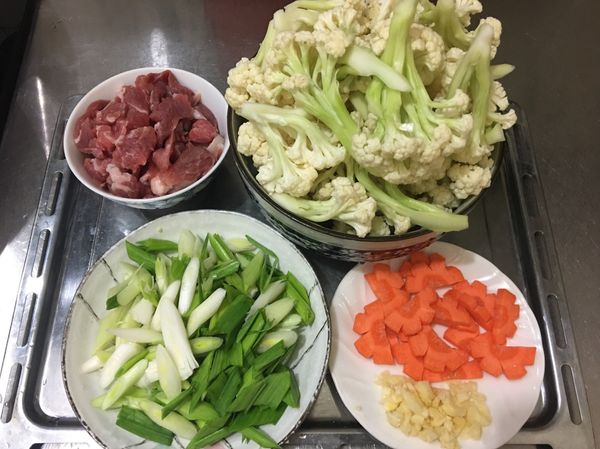 （1）白花椰菜切下每一小朵，修去皮，再切自己喜歡的大小，洗乾淨。
（2）紅蘿蔔切片。
（3）蒜頭去皮、切末。
（4）蒜苗斜切片。