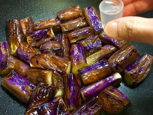 轉小火慢煎，期間可加1～2g的水，用筷子將茄子翻面煎到茄子軟化⋯