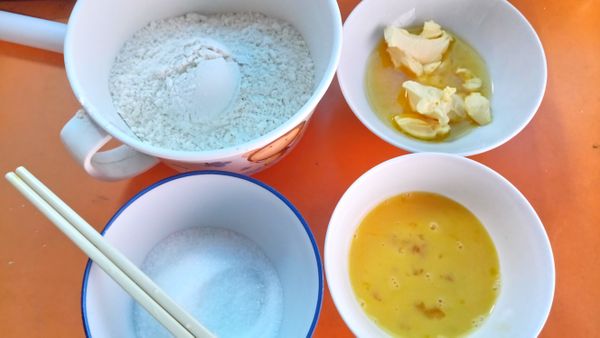 準備食材：
低筋麵粉150g+泡打粉1/4茶匙（左上）
細砂糖50g（左下）
隔水融化後的奶油40g（右上）
打勻的蛋液1顆（右下）